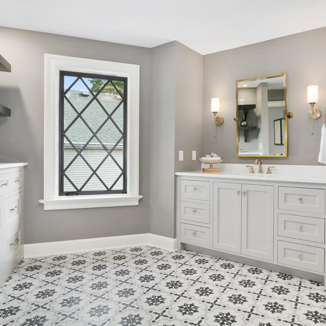 Large format gray hexagon floor tiles being installed in a bathroom.