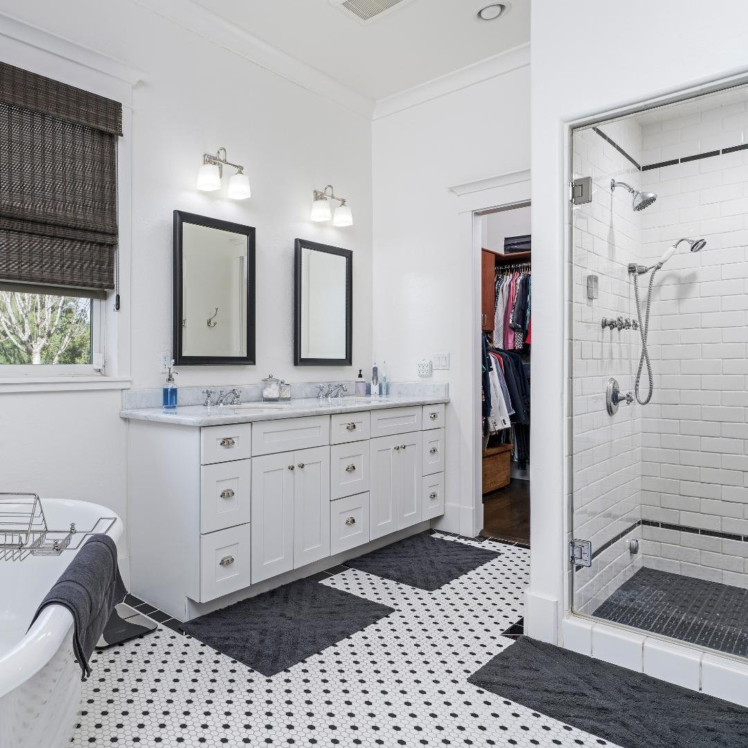 White subway tile with a gray grout line being installed on a shower wall in a bathroom.