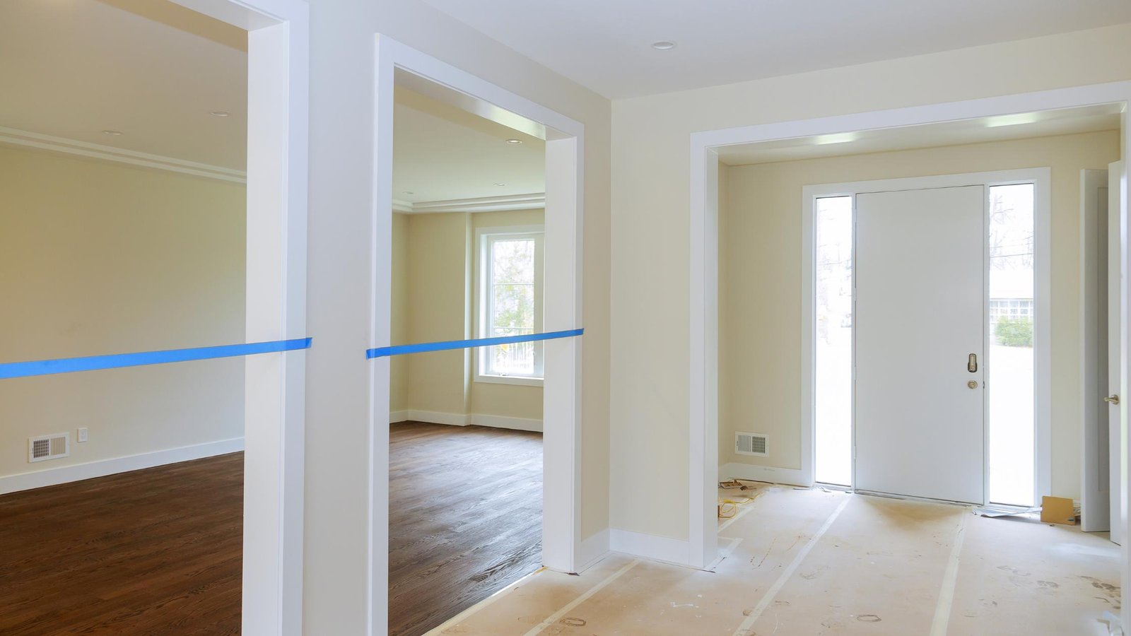 Just painted interior of a home. With taped off doorways, white trim and khaki walls.