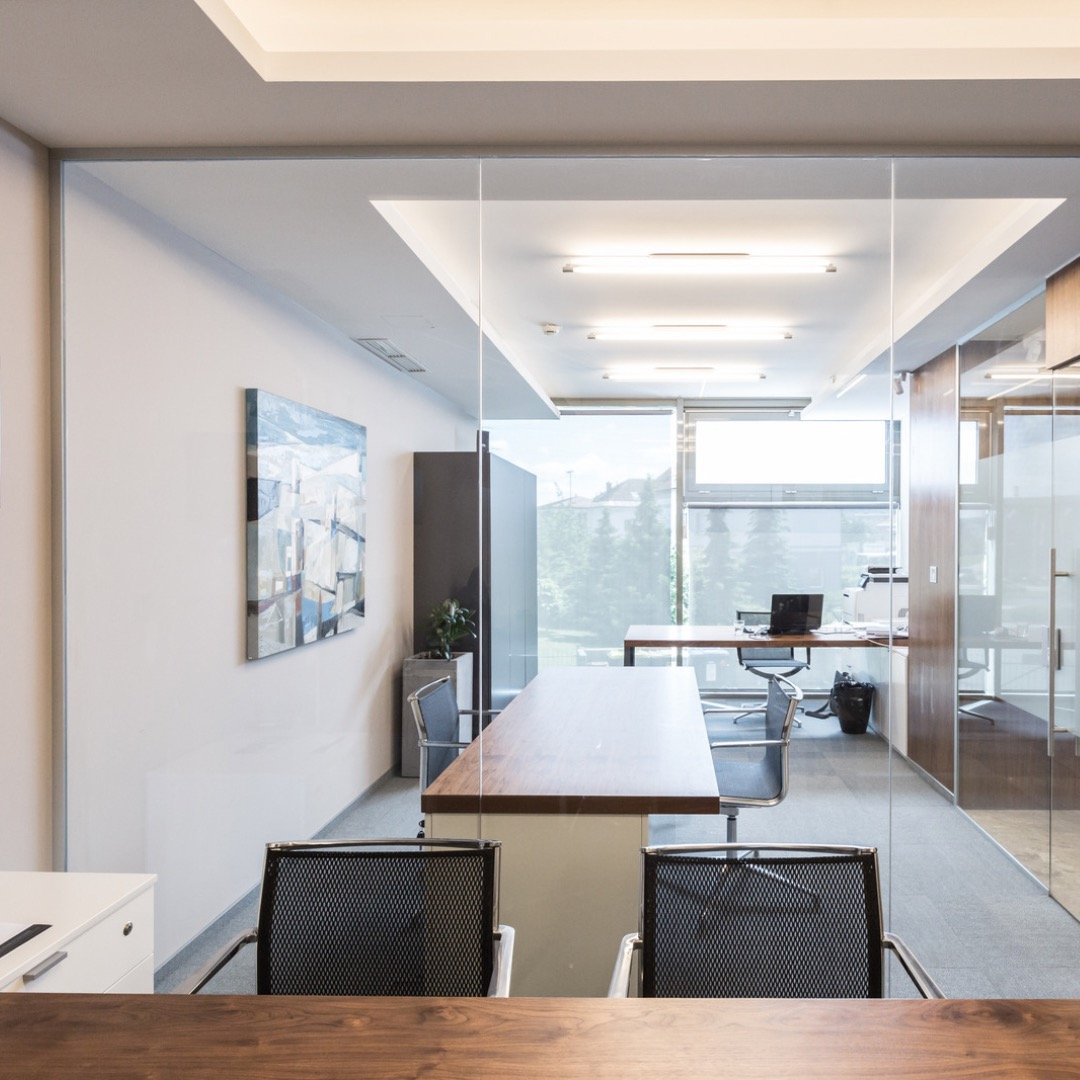 Freshly painted commercial building interior. Wood table with black chairs in the foreground.