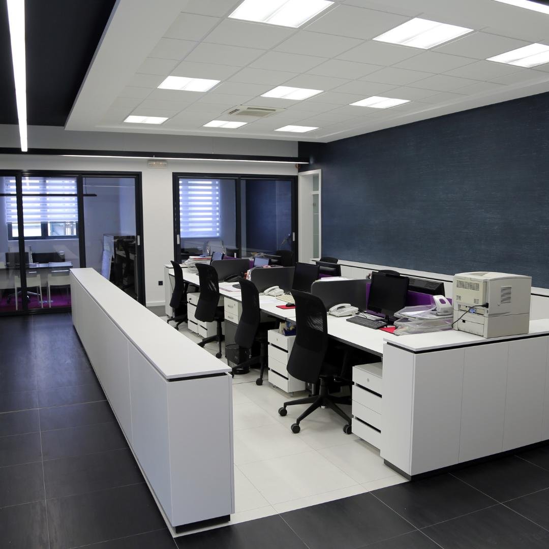 Modern office interior with white desks and chairs, finished by Artisan Painting and Remodeling.