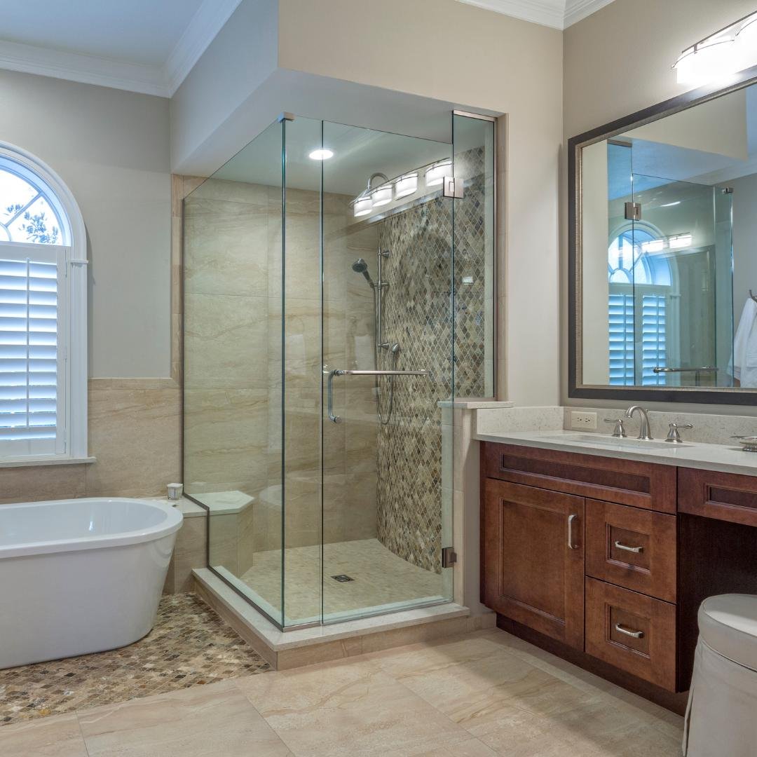 A modern walk-in shower remodel with white subway tile walls, a glass shower door, and a rain showerhead.