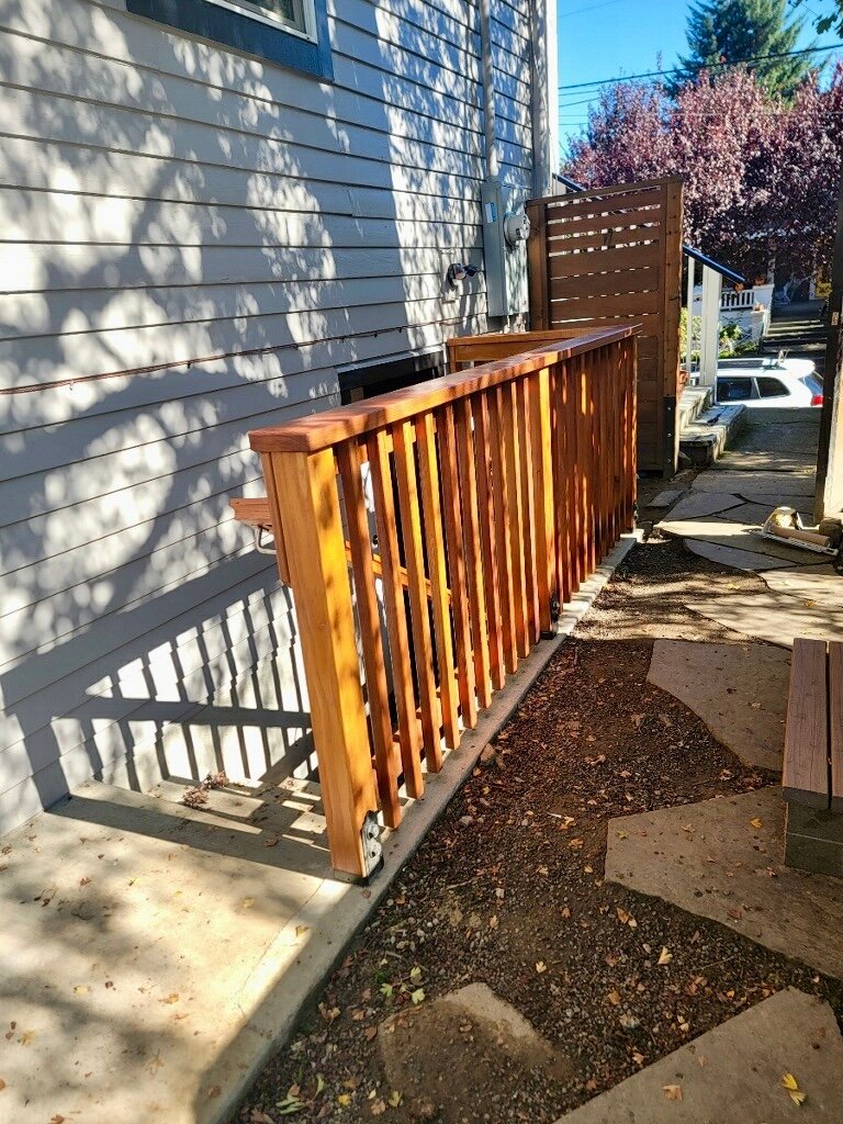 Remodeled house with wooden railing on the side of a house.